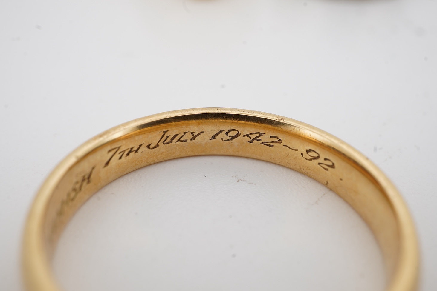 A 1990's 18ct gold wedding band, with engraved inscription, size U/V, a similar signet ring with engraved monogram and inscription, size I and an early 1970's 18ct white gold band, size O, gross weight 15.4 grams.
